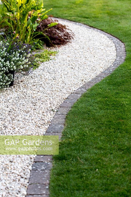 Curved gravel path with stone sett edging and lawn - Pam Woodall's garden, 'Pinecombe' in Dorset, UK