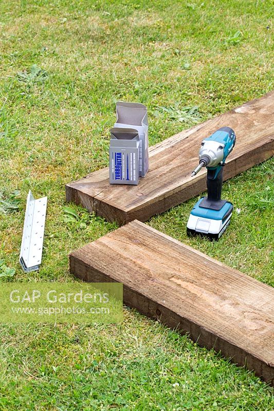 Tools and wood to create new raised bed edge. 