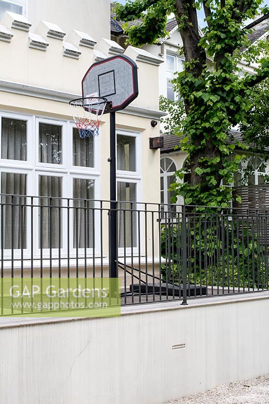 View towards house with raised wood platform 
and basketball net 
