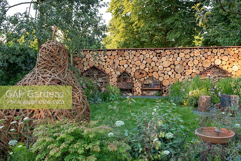 Willow Pear Pod by Ellen Mulcrone in a wildlife friendly garden with habitat wall - The Family Garden, Sponsored by Practicality Brown, Marshalls, The Tree Company, RHS Hampton Court Palace Flower Show, 2018. 