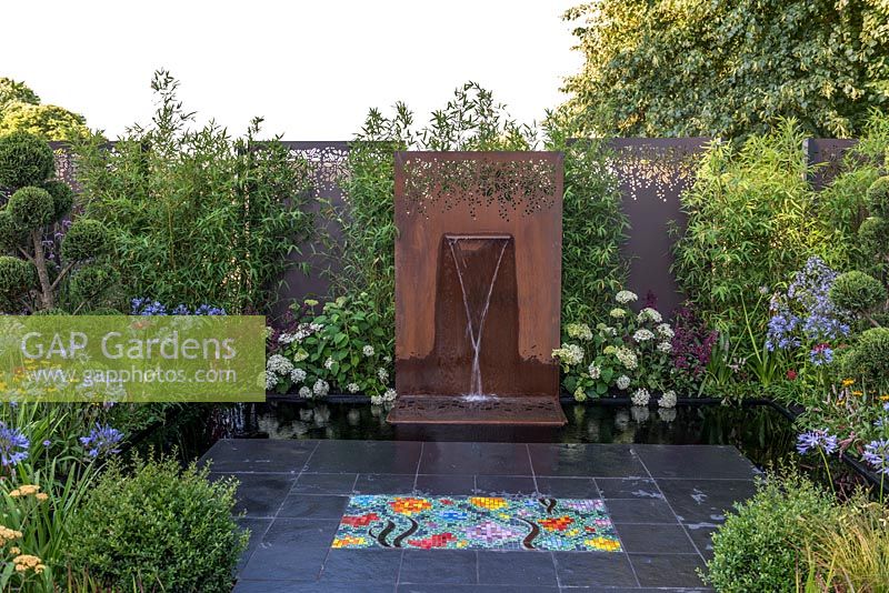 Corten steel water feature in The Colour Box Garden - Sponsored by Stark and Greensmith, Simon Probyn Sculpture, Nickie Bonn and Art4Space at RHS Hampton Court Flower Show 2018 