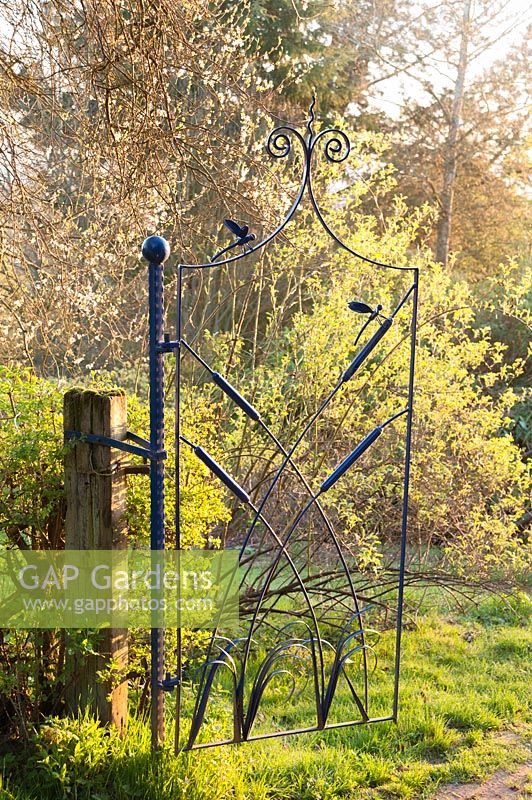 Gate by Dave Bissell of dragonflies and bulrushes. Moors Meadow Garden and Nursery, Bromyard, Herefordshire, UK
