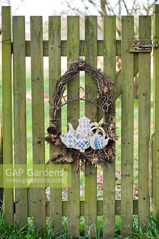 Close up of Autumnal wreath with welcome sign on wooden gate. 