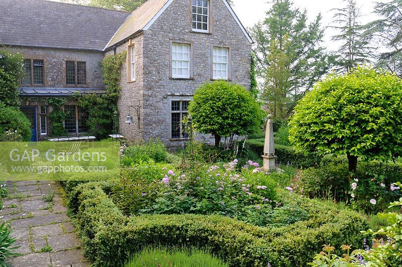 Formal courtyard garden with clipped Buxus hedges and obelisks. 