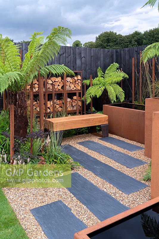 Steel wood store - Bee's Gardens: The Penumbra, Sponsored by CED Stone Group, Oxford Oak, The Pot Company, RHS Tatton Park Flower Show, 2018. 

