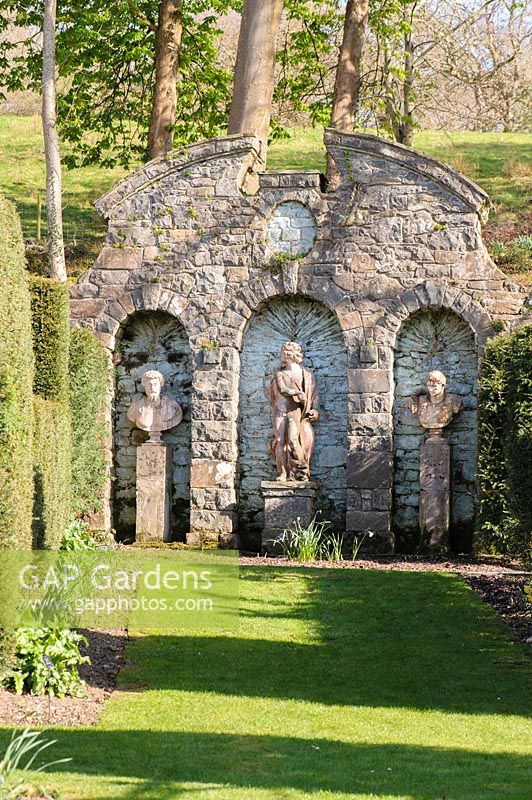 Cupid's Folly features a statue of Apollo flanked by a pair of classical busts. Plas Brondanw, Penrhyndeudraeth, Gwynedd, Wales