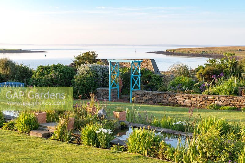 View of coastal garden with 18-metre long rill edged with Iris. 

