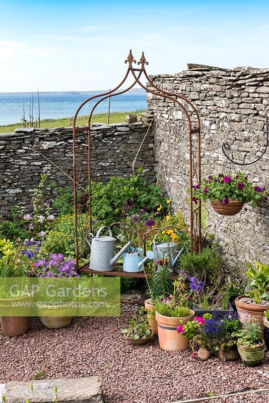 Tall dry stone wall wards off sea breezes from a small courtyard.