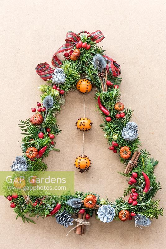 View of finished Christmas tree-shaped festive door wreath, made using natural materials. 