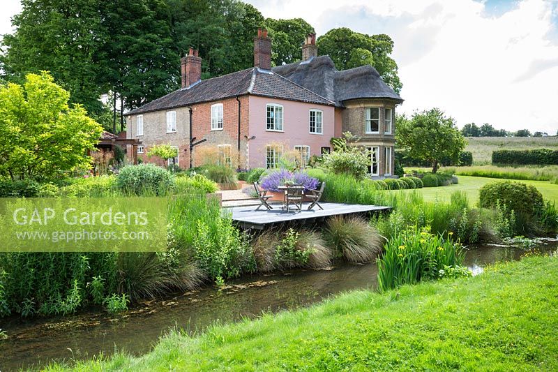 View accross the river to the house and garden, Norfolk, UK.