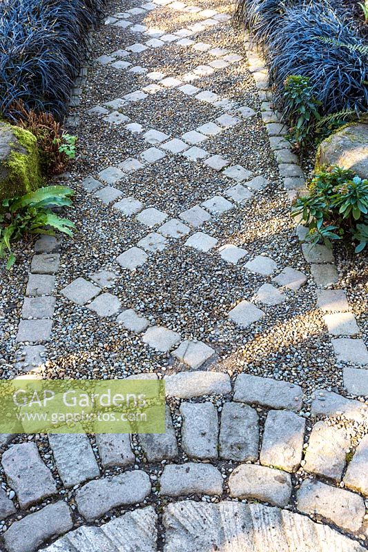 Ornate path edged with Ophiopogon planiscapus Nigrescens, York Gate Garden, Leeds