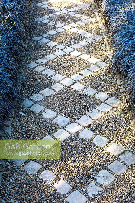 Ornate path edged with Ophiopogon planiscapus 'Nigrescens', York Gate Garden, Leeds, UK.  