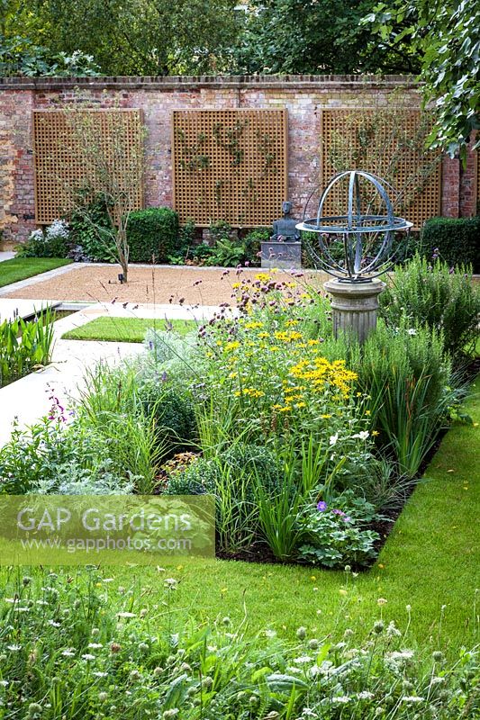 Armillary Sundial in mixed bed. Garden Design by Peter Reader Landscapes.