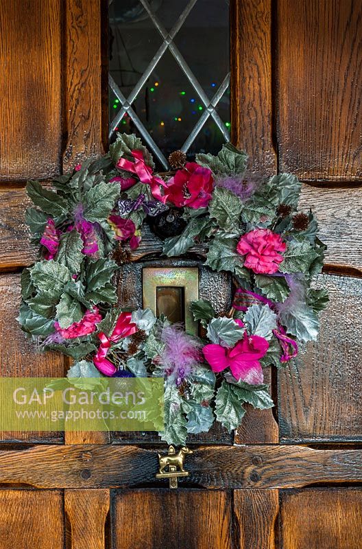 View of Christmas wreath on wooden front door.