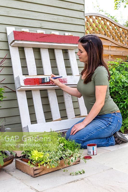 Painting white pallet planter red.