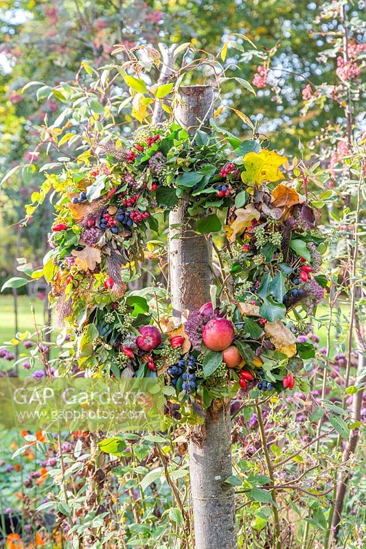 Finished wreath hanging from wood post in garden