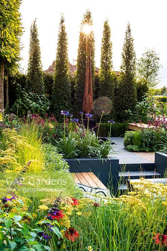 Modern garden with sculpture and seating area. 
Best of Both Worlds garden
RHS Hampton Court Palace Flower Show 2018