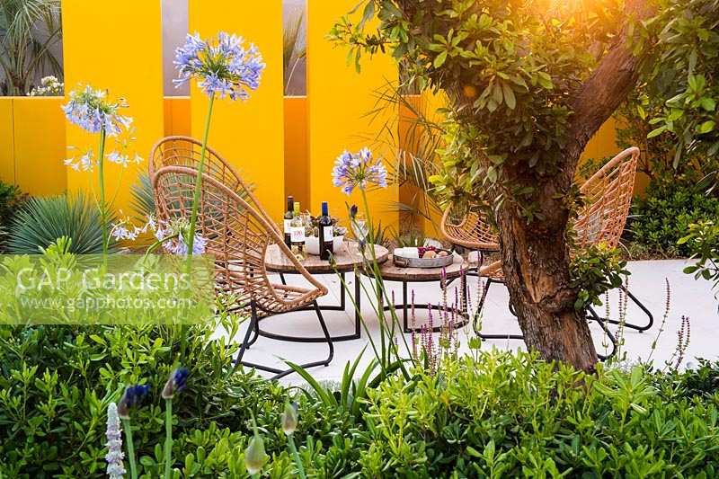 Seating area in drought tolerant garden. Santa Rita 'Living La Vida 120' Garden, Sponsored by Santa Rita Wines, RHS Hampton Court Flower Show, 2018.
