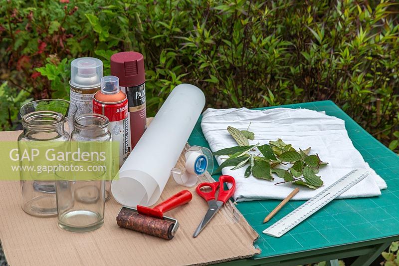 Tools and materials for making leaf-printed candle holder decorations.