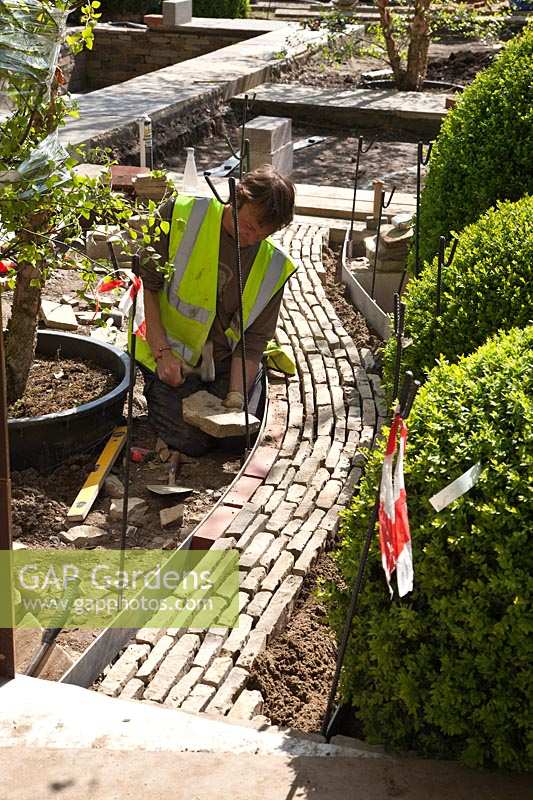 Laying a path of drystone setts in preparation for RHS Chelsea Flower Show. 