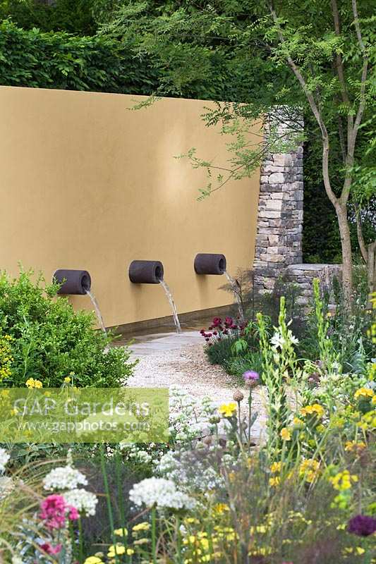 Yellow wall with water spouts. Daily Telegraph Garden, RHS Chelsea Flower Show, 2011.