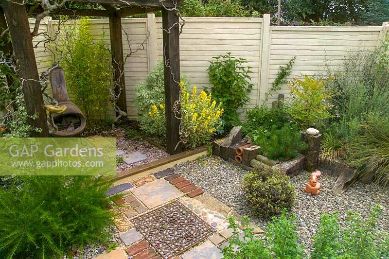 Small patio style garden with hard landscaping in different materials. 