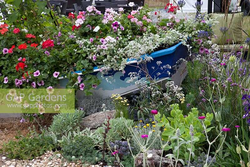 Old boat with bedding plants, 'Fun On Sea' Southend-on-Sea garden, Hampton Court Palace Flower Show, 2017