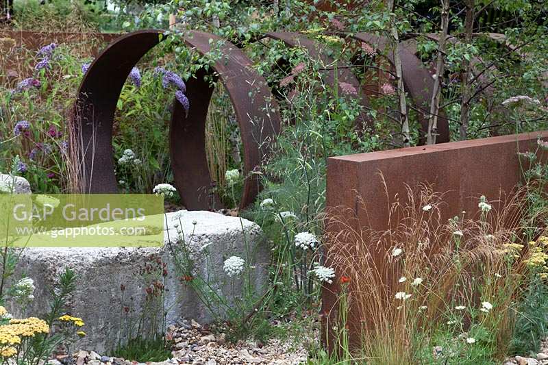 Detail of monolothic steel structures and wildflowers in Brownfield - Metamorphosis garden at Hampton Court Flower Show, London, 2017.
