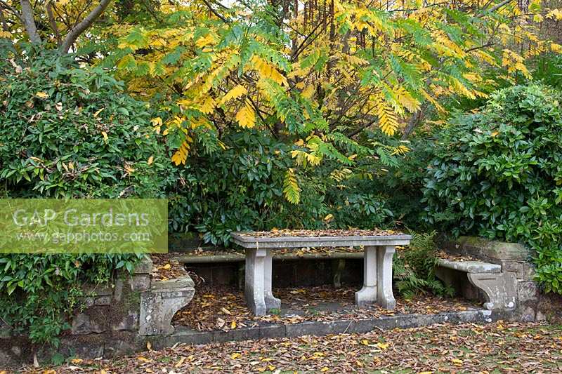 Formal stone bench in autumn. Gravetye Manor, Sussex, UK. 