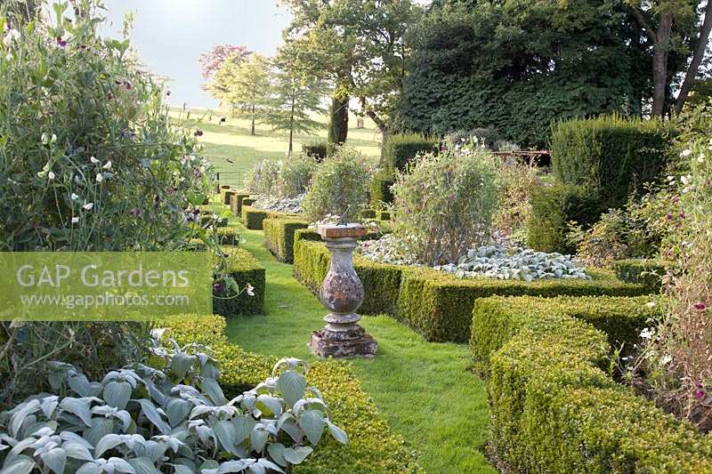 Formal parterre with sundial and countryside beyond, Oxfordshire, UK