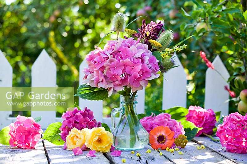 Flower arrangement with hydrangea and roses in garden table. 