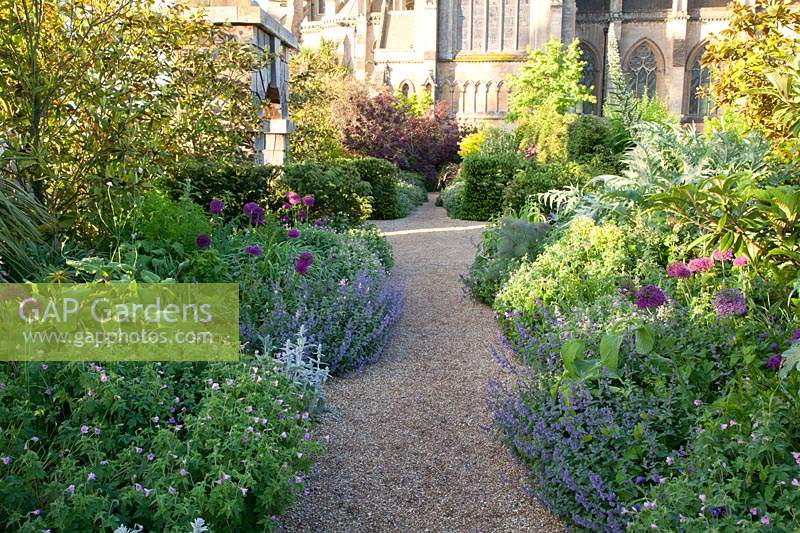 Gravel pathway bordered by mixed perennial flowerbeds. Arundel Castle, West Sussex, UK. 