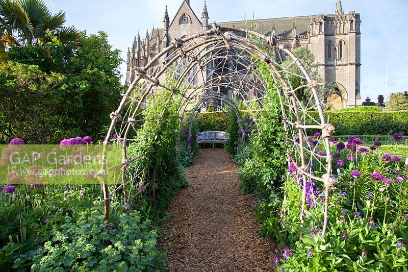 View through rustic arbour to wooden bench and Cathedral beyond. Arundel Castle, Sussex, UK. 