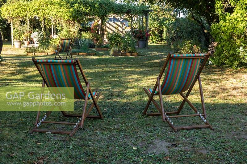 Deck chairs on lawn with view of garden beyond