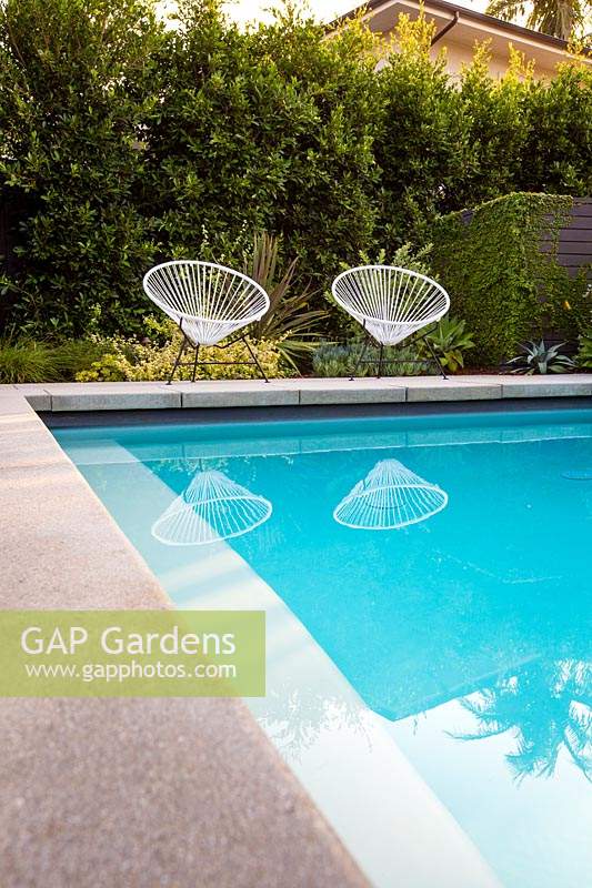 A pair of vintage Acapulco garden chairs by the swimming pool in Californian Garden. Designed by Falling Waters Landscape, inc Ryan Prange, New Port Beach, California, USA.