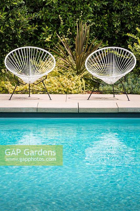A pair of vintage Acapulco garden chairs by the swimming pool in Californian Garden. Designed by Falling Waters Landscape, inc Ryan Prange, New Port Beach, California, USA.
