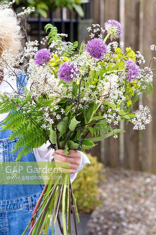 Woman arranging bouquet of spring flowers.