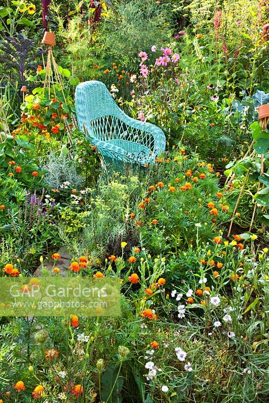 Relaxing area amongst a potager of flowers and herbs