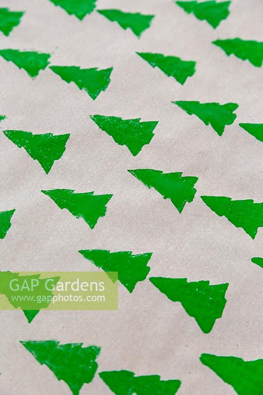 Brown wrapping paper stamped with continuous christmas tree pattern.
