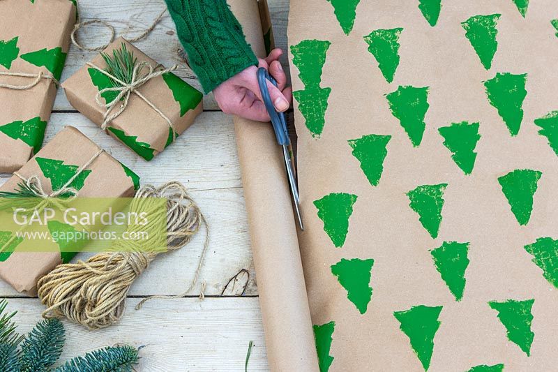 Cutting hand-stamped, Christmas-themed wrapping paper from roll