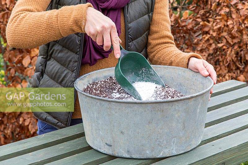 Woman mixing perlite into compost make it lighter and aerated