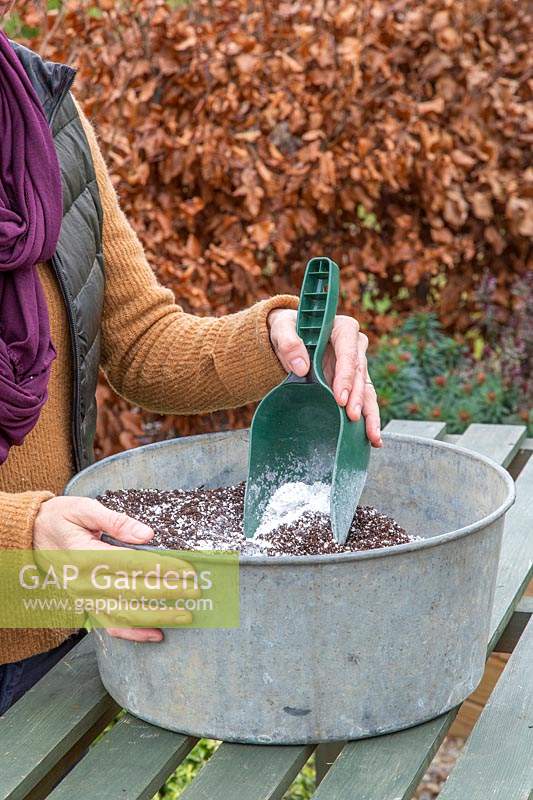 Woman mixing perlite into compost make it lighter. 