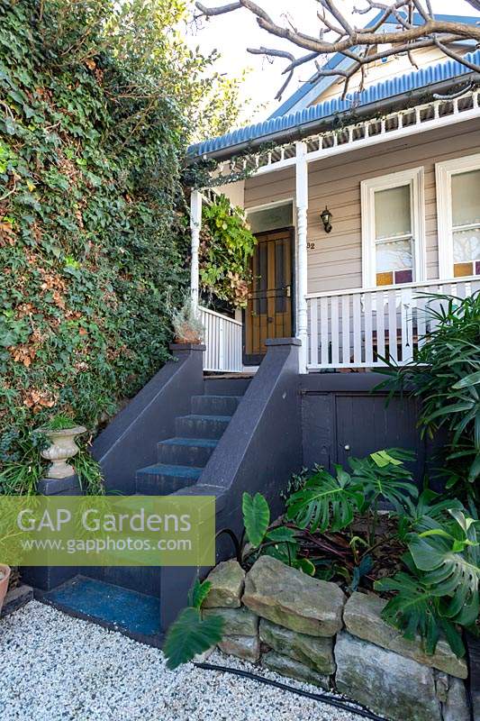Front steps leading to a verandah of a Victorian-style cottage. 