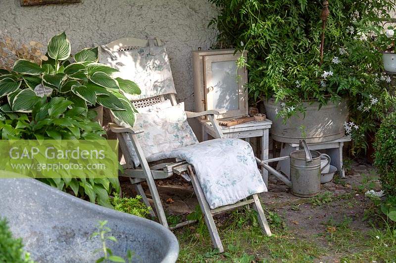 Vintage garden decoration with recliner, zinc pots and old watering can