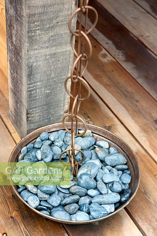 Close up of rain chain with copper bowl of pebbles in the teahouse. 
