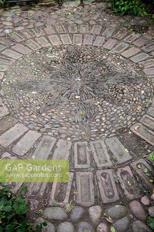 Circular pattern made from brick, pebble mosaic and cobbles
 