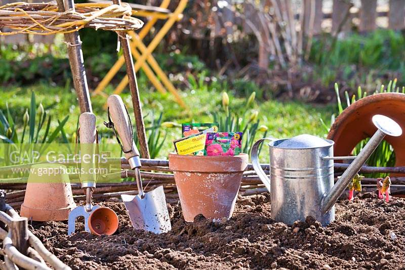 Tools and equipment laid out for working in a vegetable garden.
