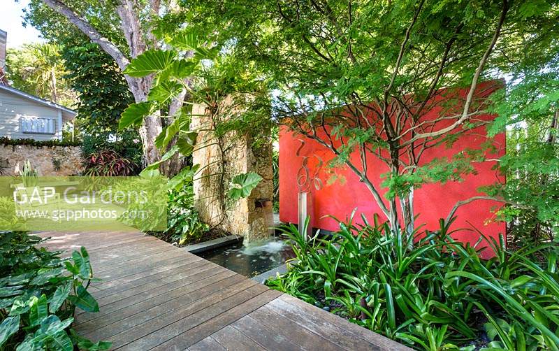Shaded wooden pathway in tropical garden. Von Phister Residence, Key West, Florida, USA. Garden design by Craig Reynolds.