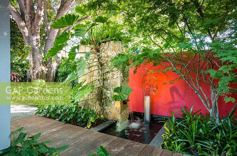 Shaded wooden pathway in tropical garden. Von Phister Residence, Key West, Florida, USA. Garden design by Craig Reynolds.