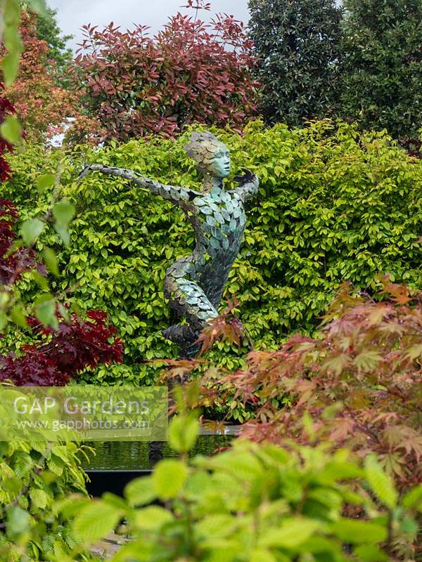 'The Leaf Creative Garden: A Garden of Quiet Contemplation' - view through foliage to sculpture by Simon Gudgeon.